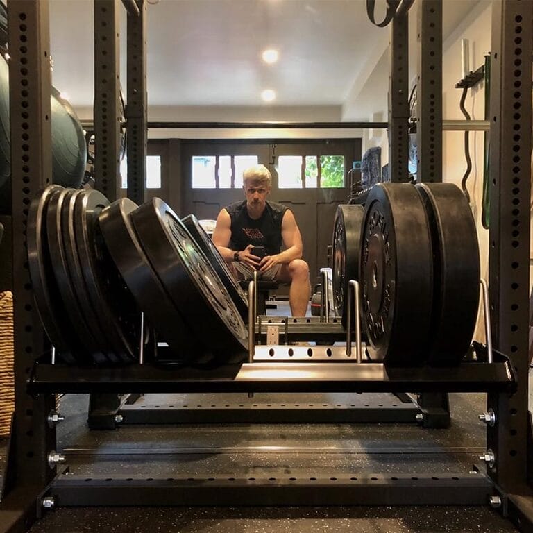 Nate Clark sitting in front of a squat rack in his home gym